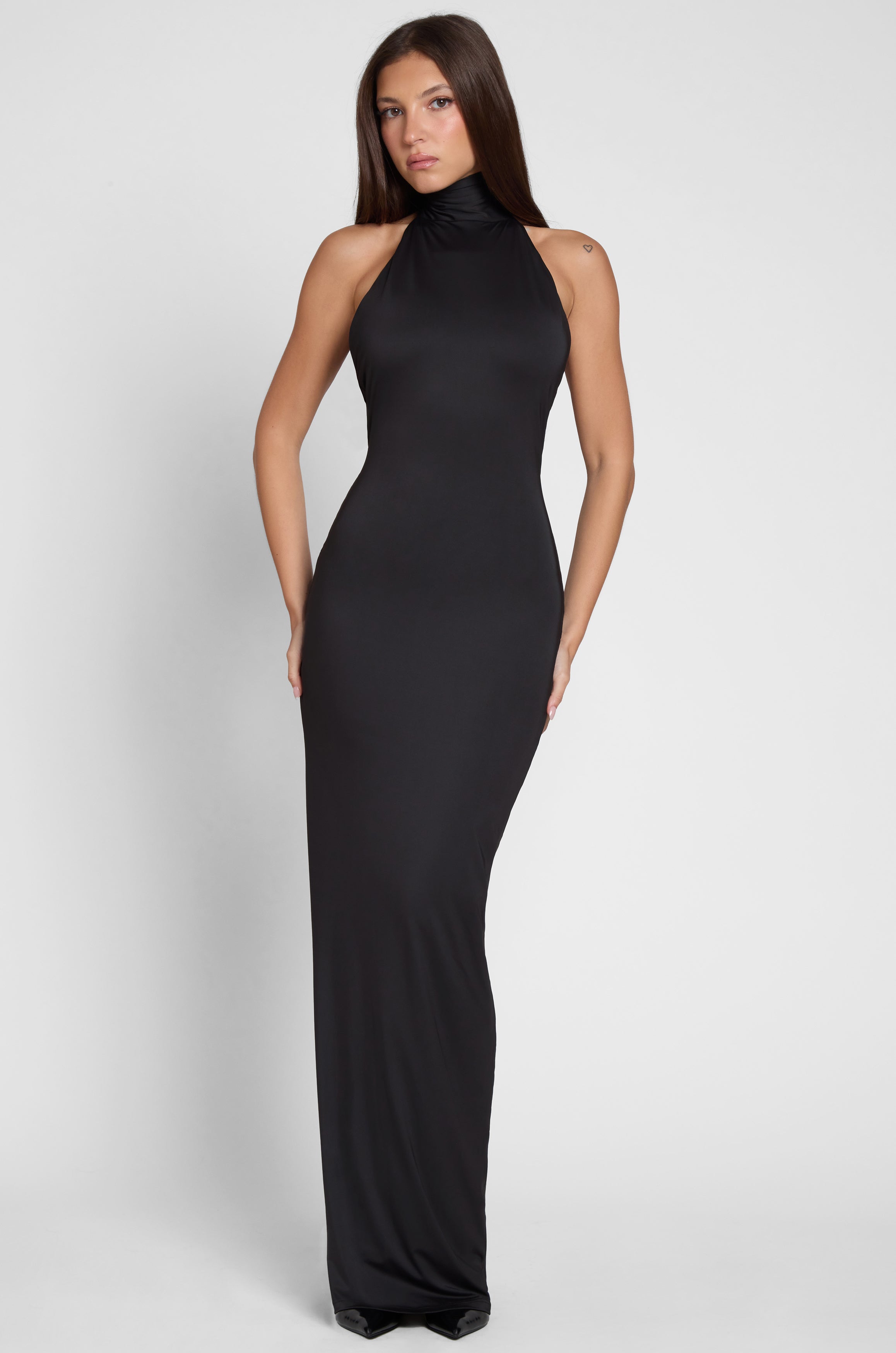 Model is wearing Alaia Drape Maxi Dress Black, front view.