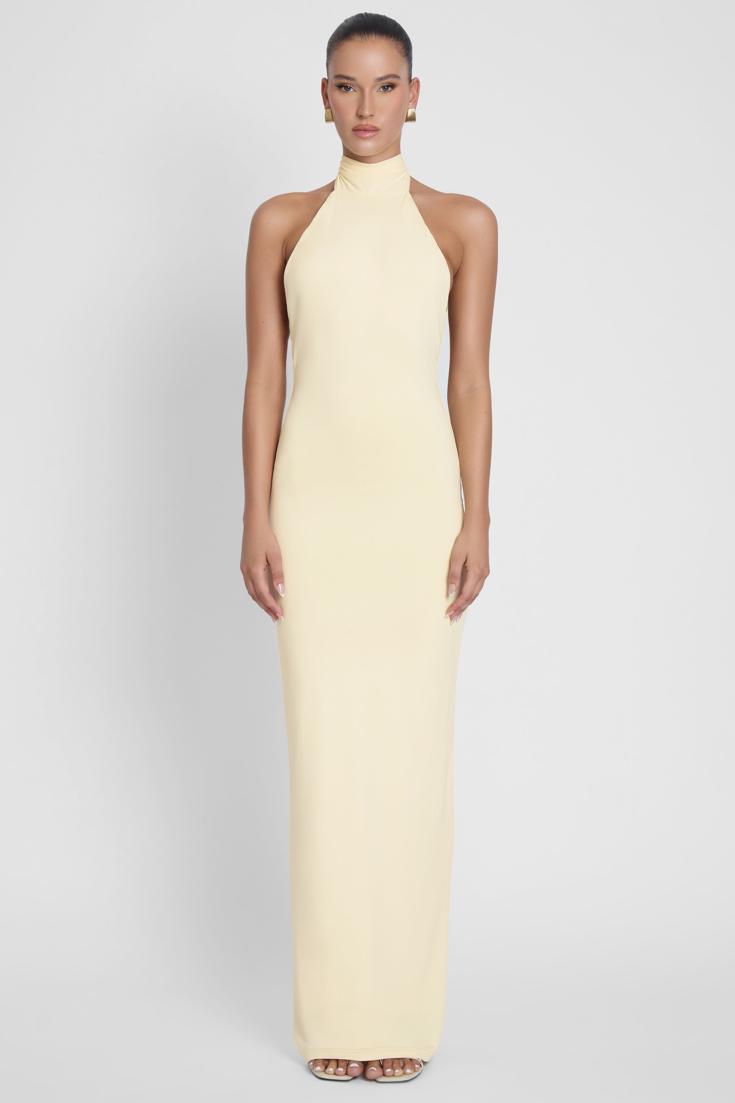 Model is wearing Alaia Drape Maxi Dress Yellow, front view.