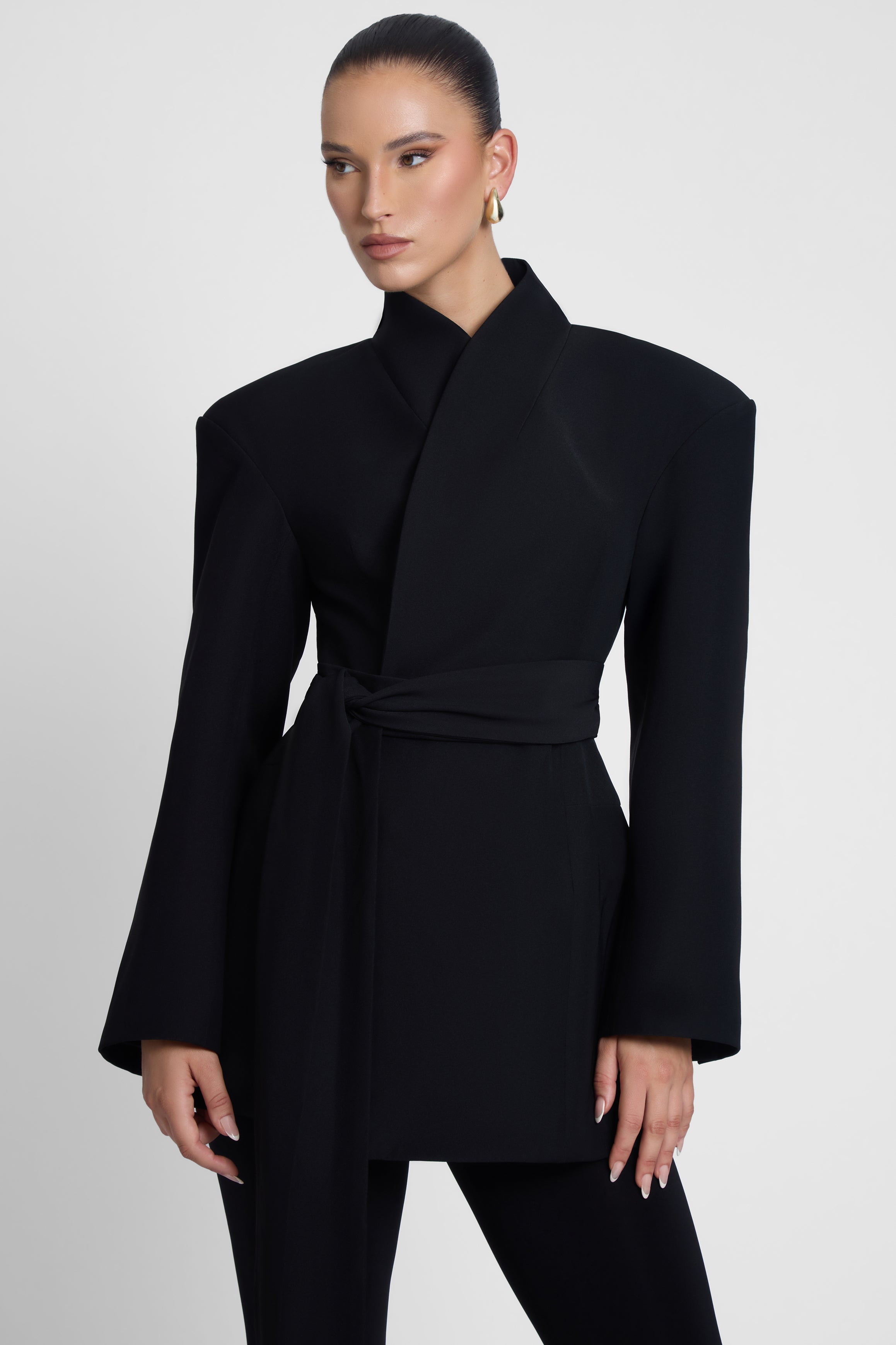 Model is wearing Cairo Hourglass Belted Coat Black, front view.