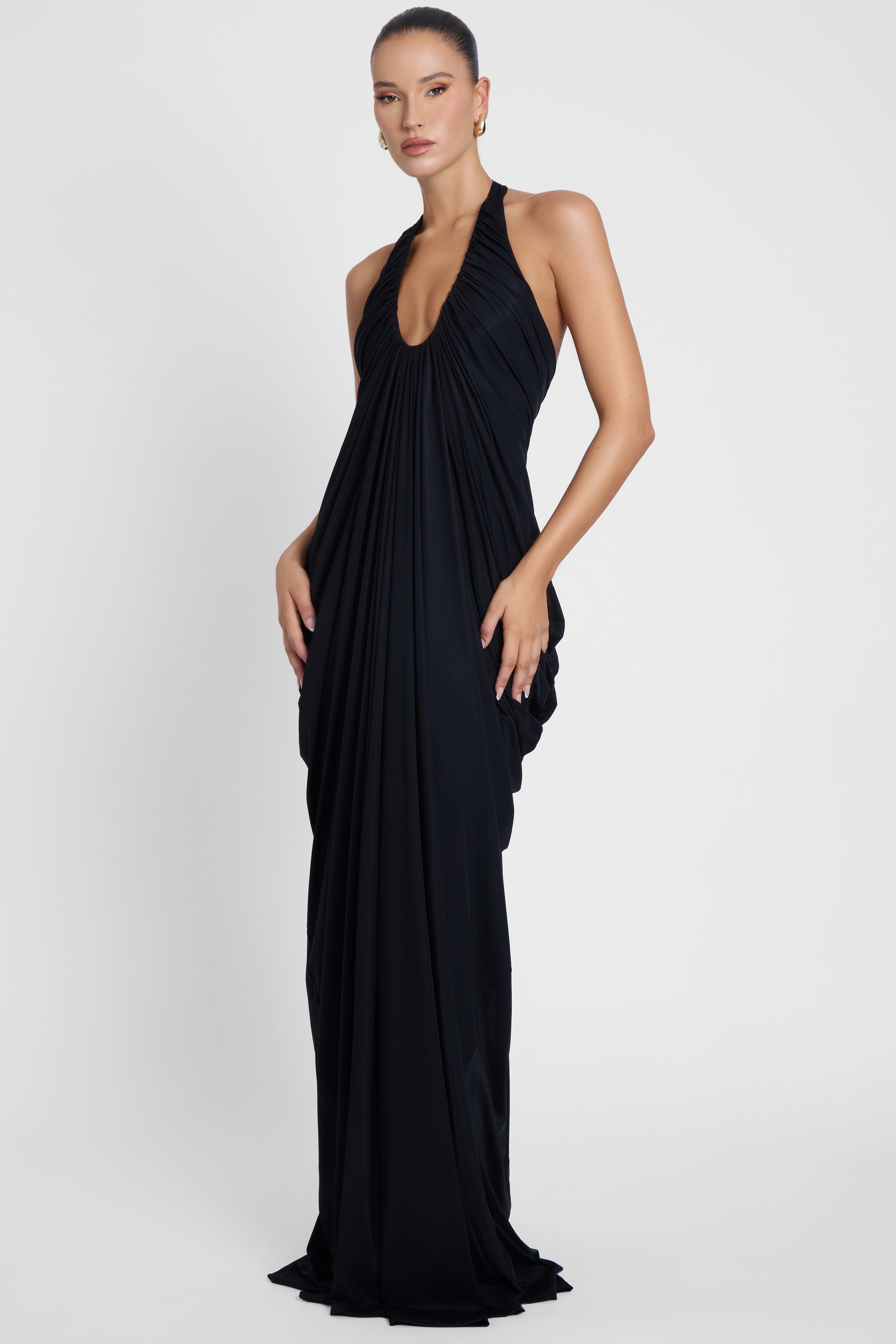 Model is wearing Cascade Drape Gown Black in Black, front view.