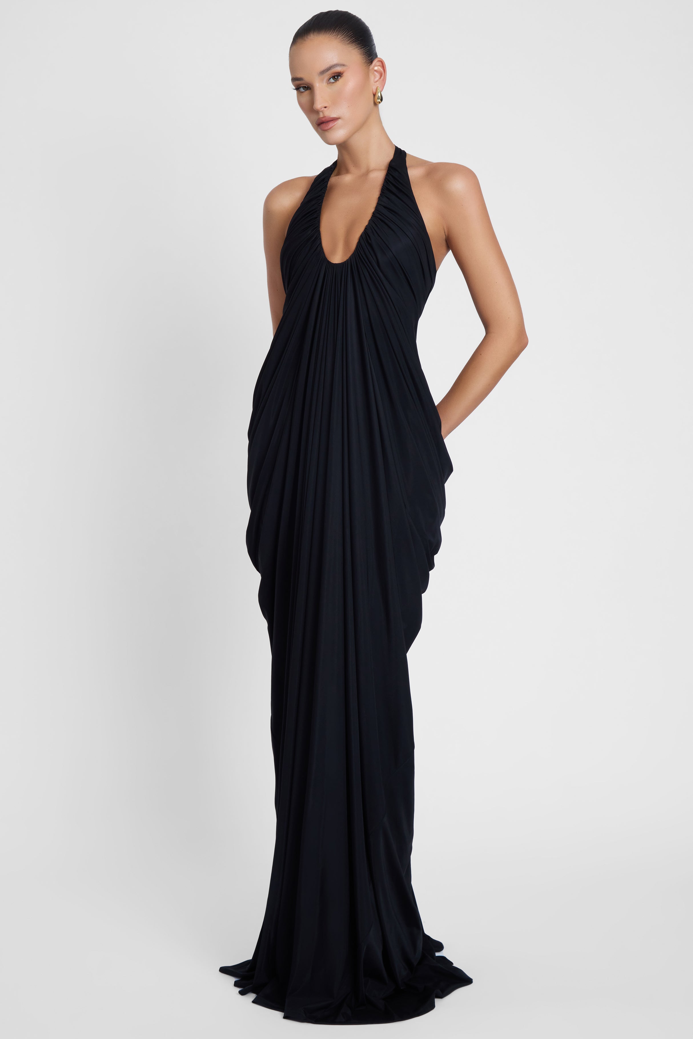 Model is wearing Cascade Drape Gown Black in Black, front view.