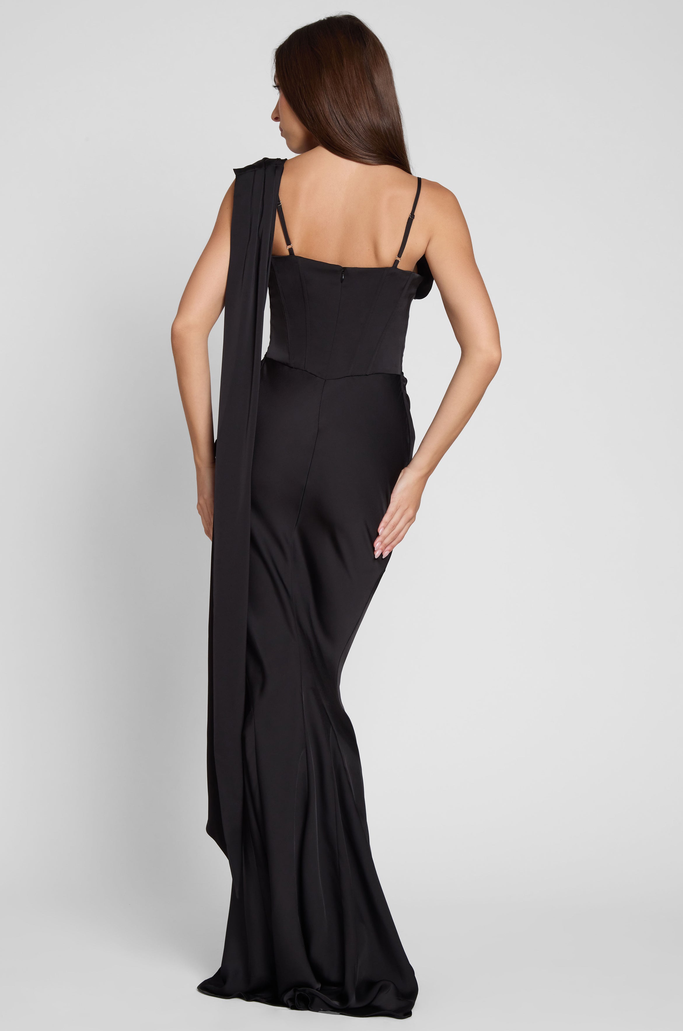 Model is wearing Celine Corset Drape Satin Gown in Black, back view.