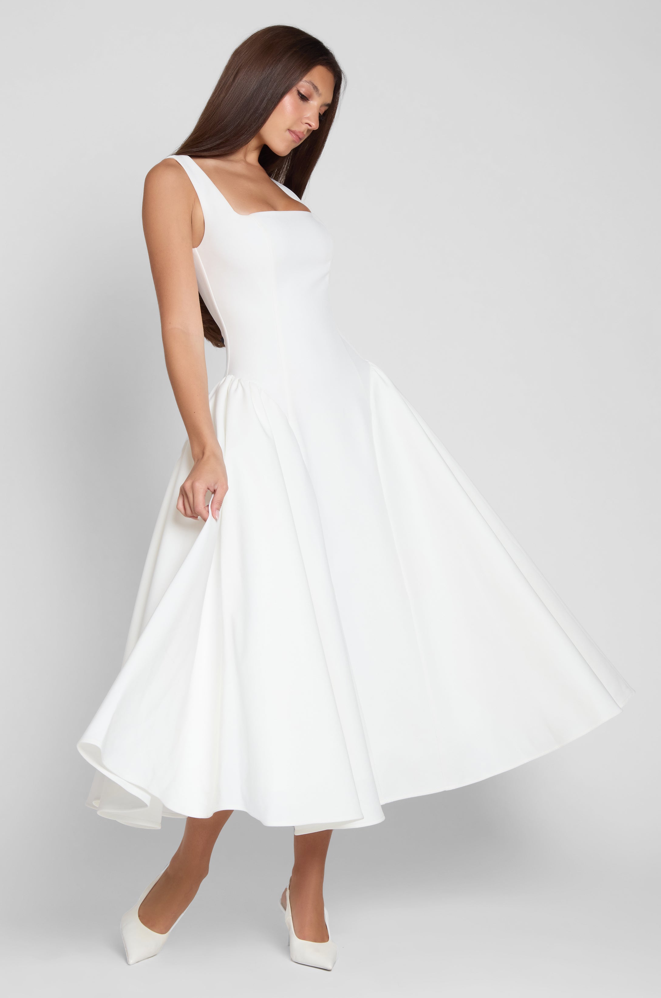 Model is wearing Chloe Corset Midi Dress White, side view.