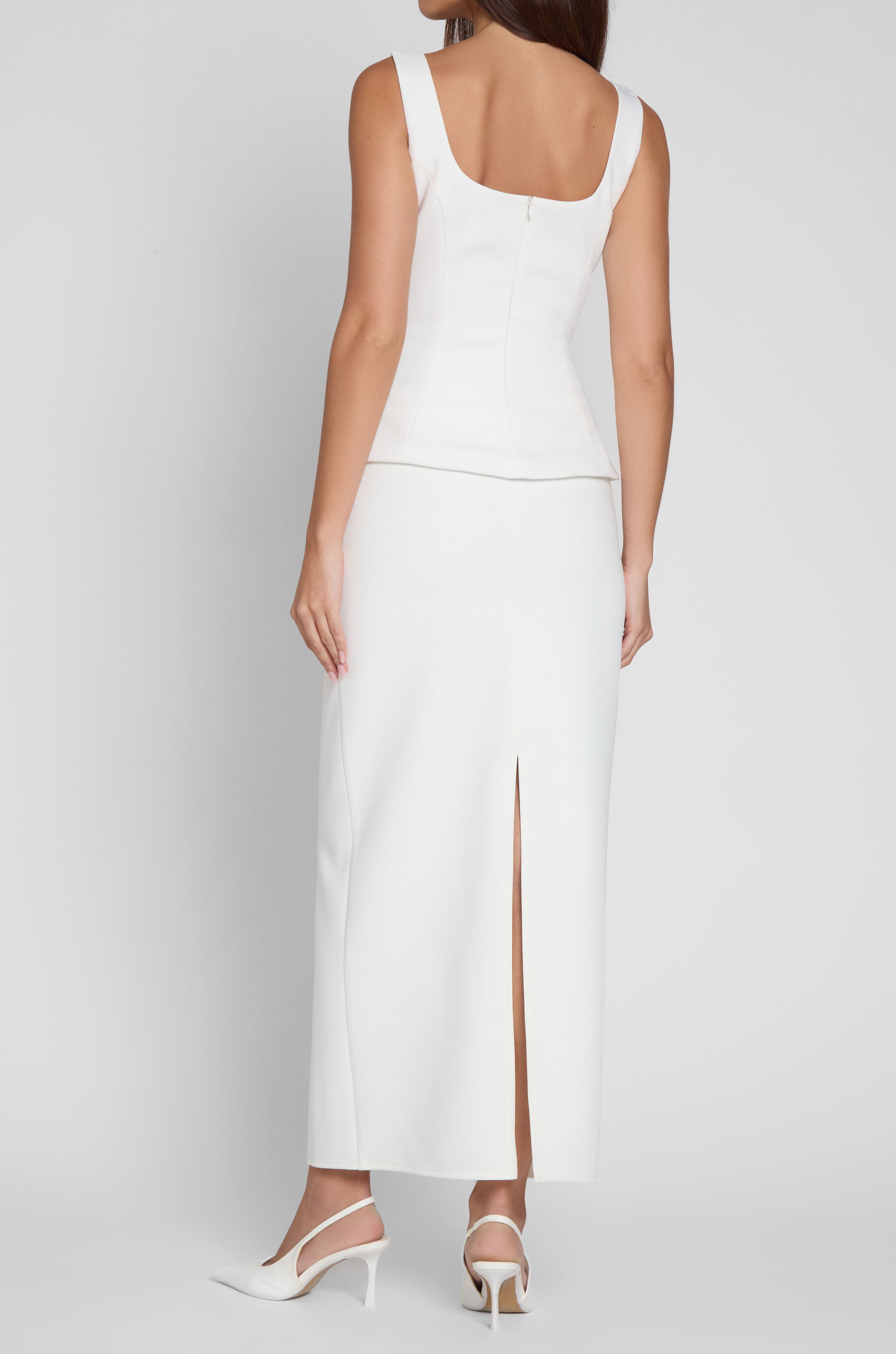 Model is wearing Classic Column Maxi Skirt in White, back view.