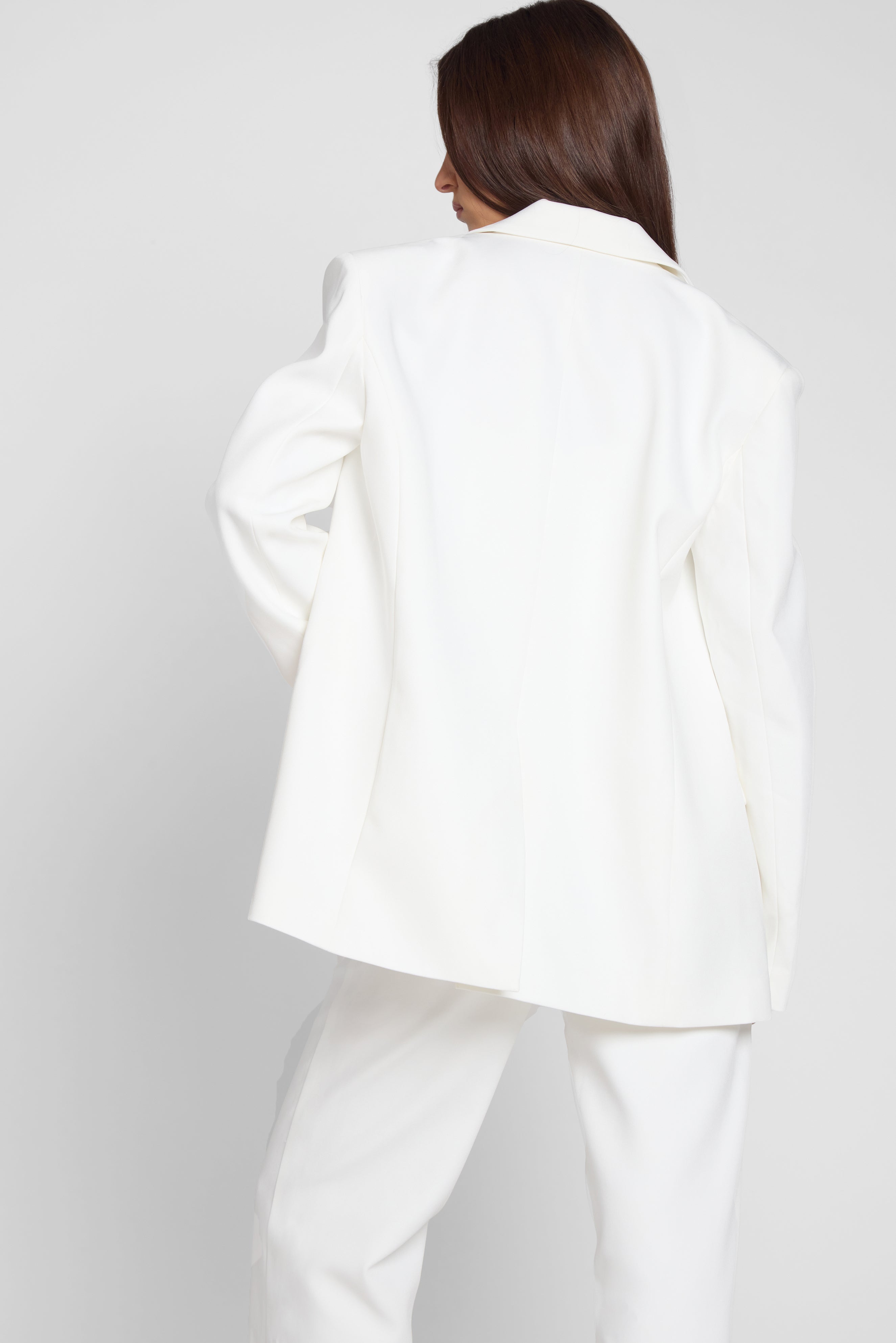 Model is wearing Classic Column Oversized Blazer in White, back view.