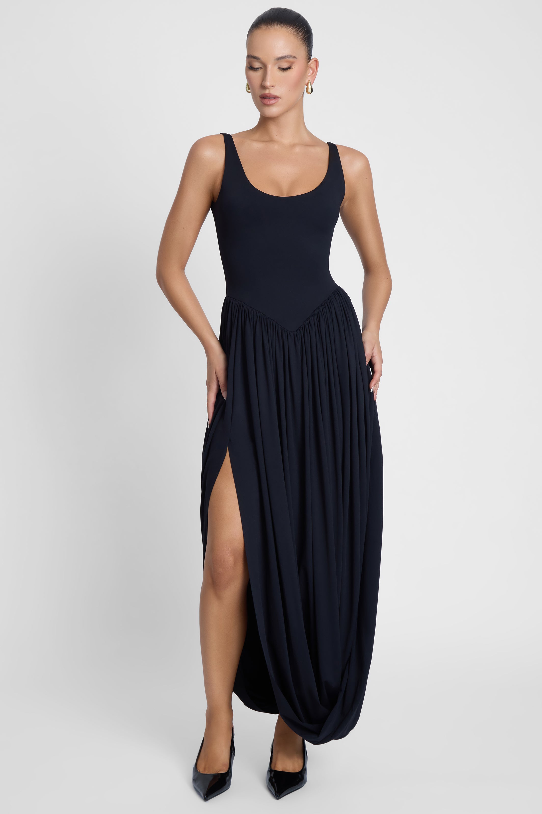 Model is wearing Dionysus Sculpt Drape Midi Dress, front view.