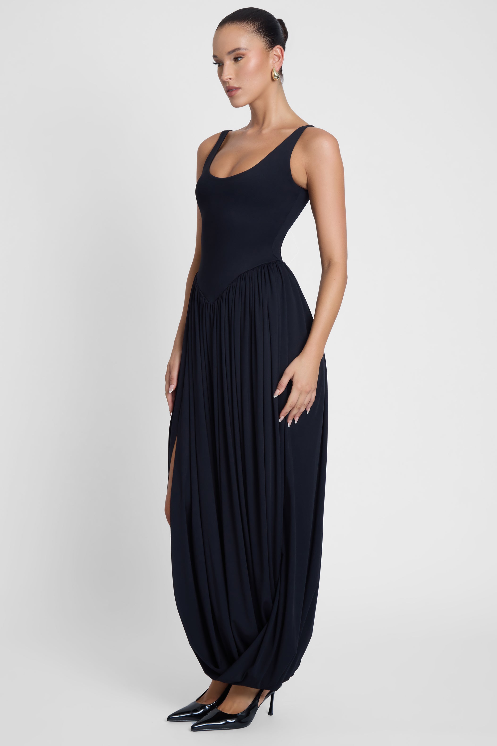 Model is wearing Dionysus Sculpt Drape Midi Dress, side view.