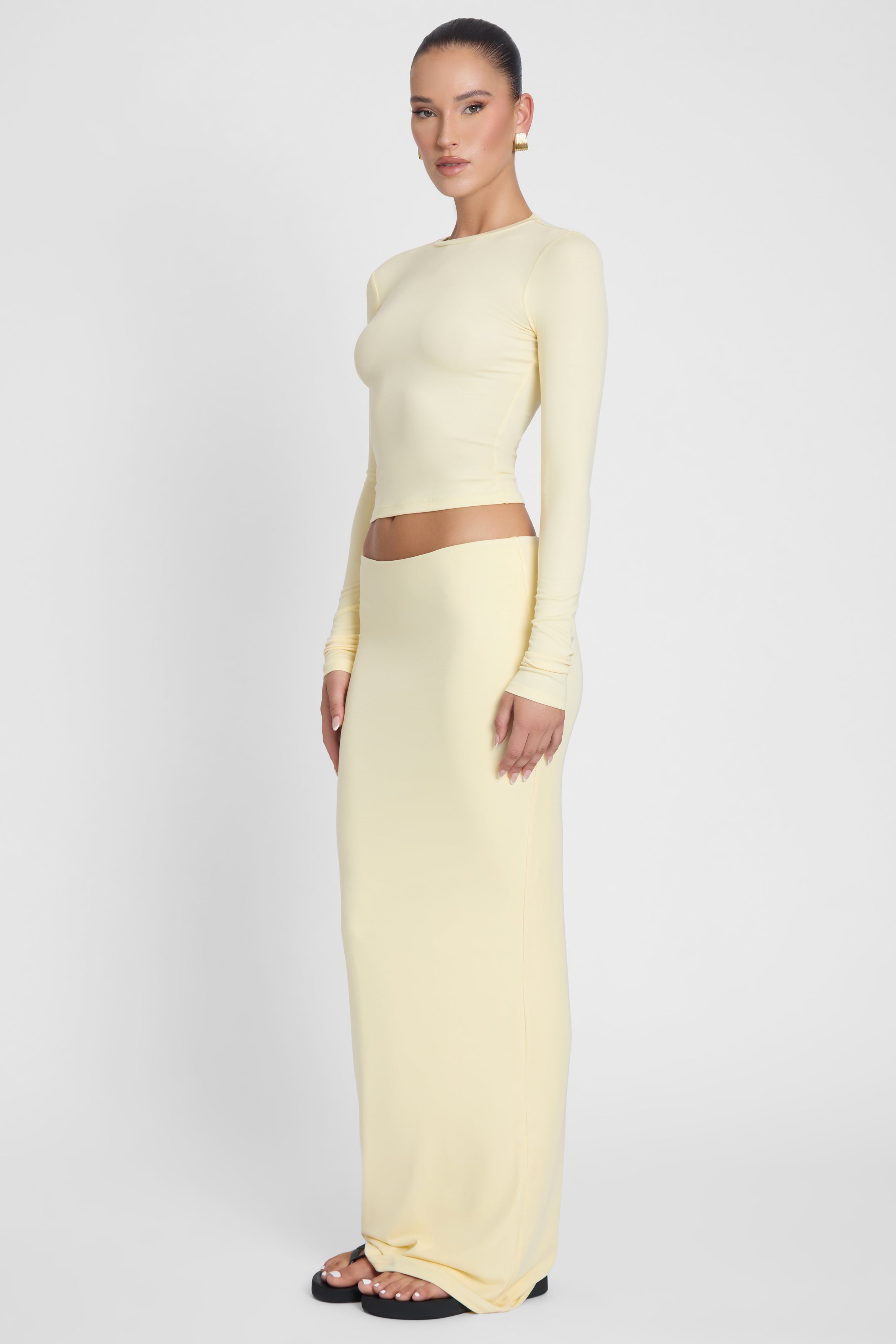 Model is wearing Everyday Jersey Long Sleeve Top Yellow, side view.