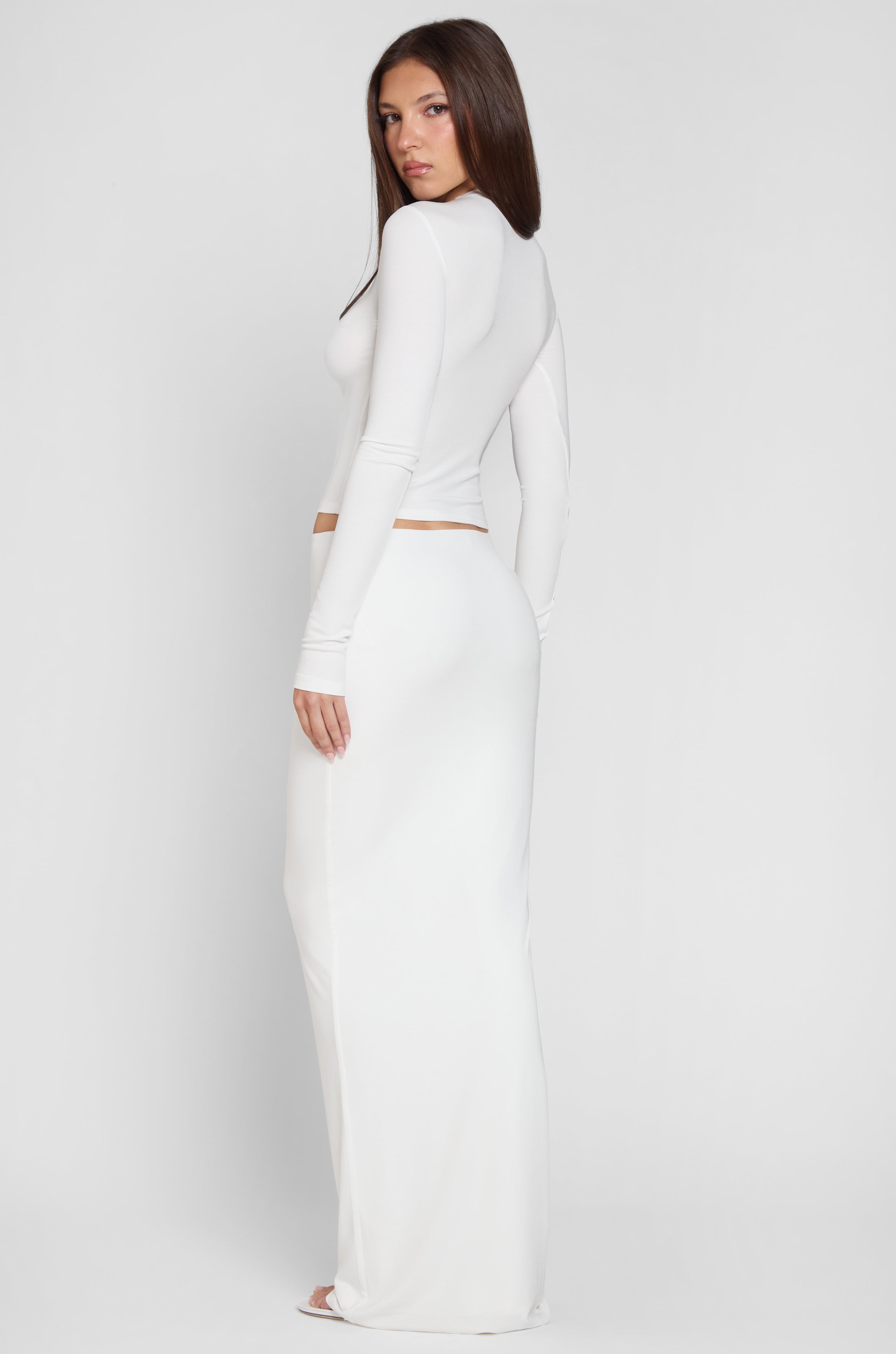 Model is wearing Everyday Jersey Maxi Skirt in White, back view.