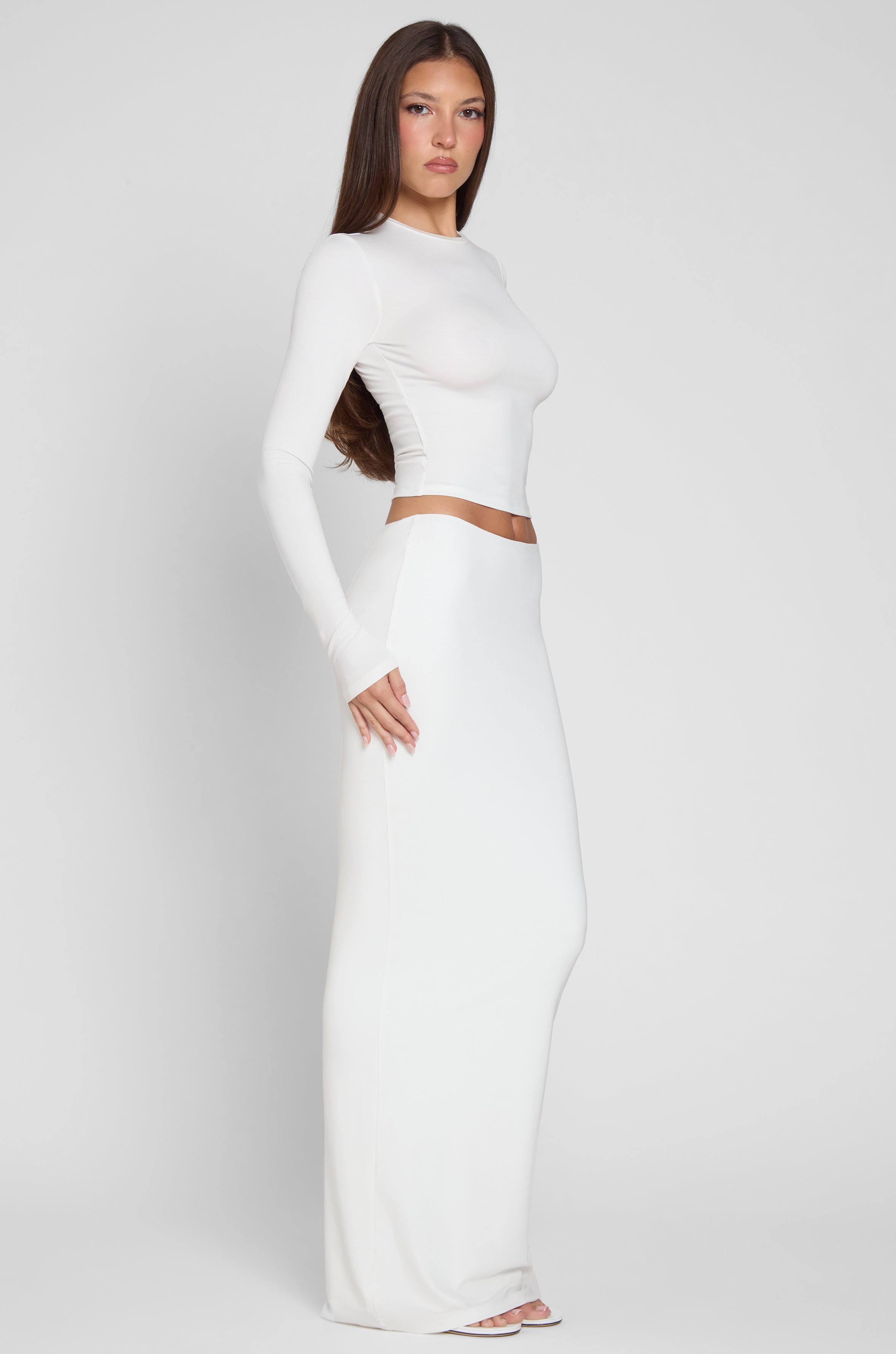 Model is wearing Everyday Jersey Maxi Skirt in White, side view.