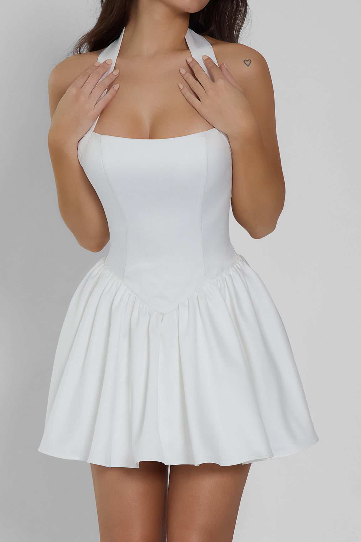 Model wearing Hyades Halter Corset Mini Dress in White, front view.