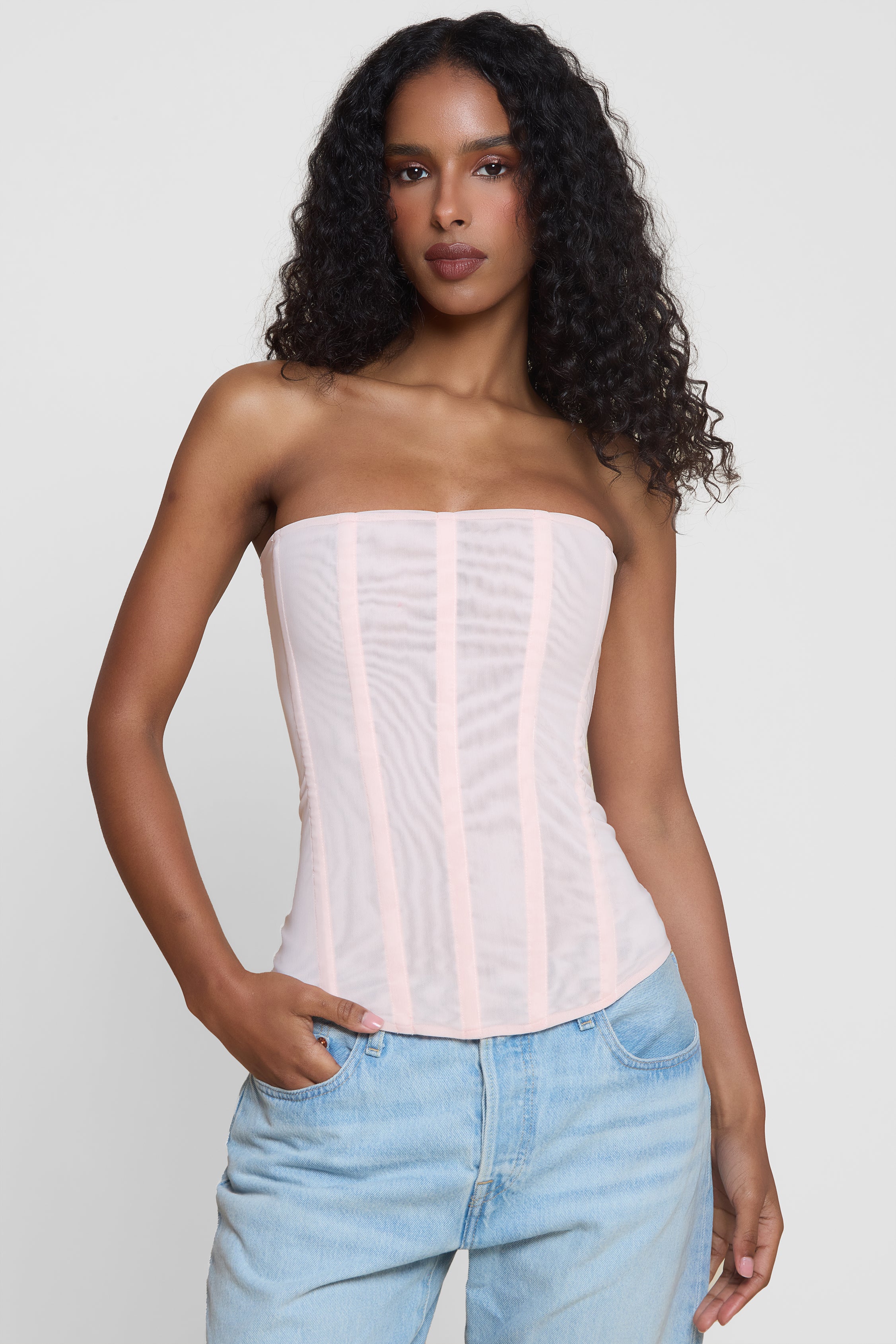 Model wearing Muse Mesh Corset Top in Pink, front view.