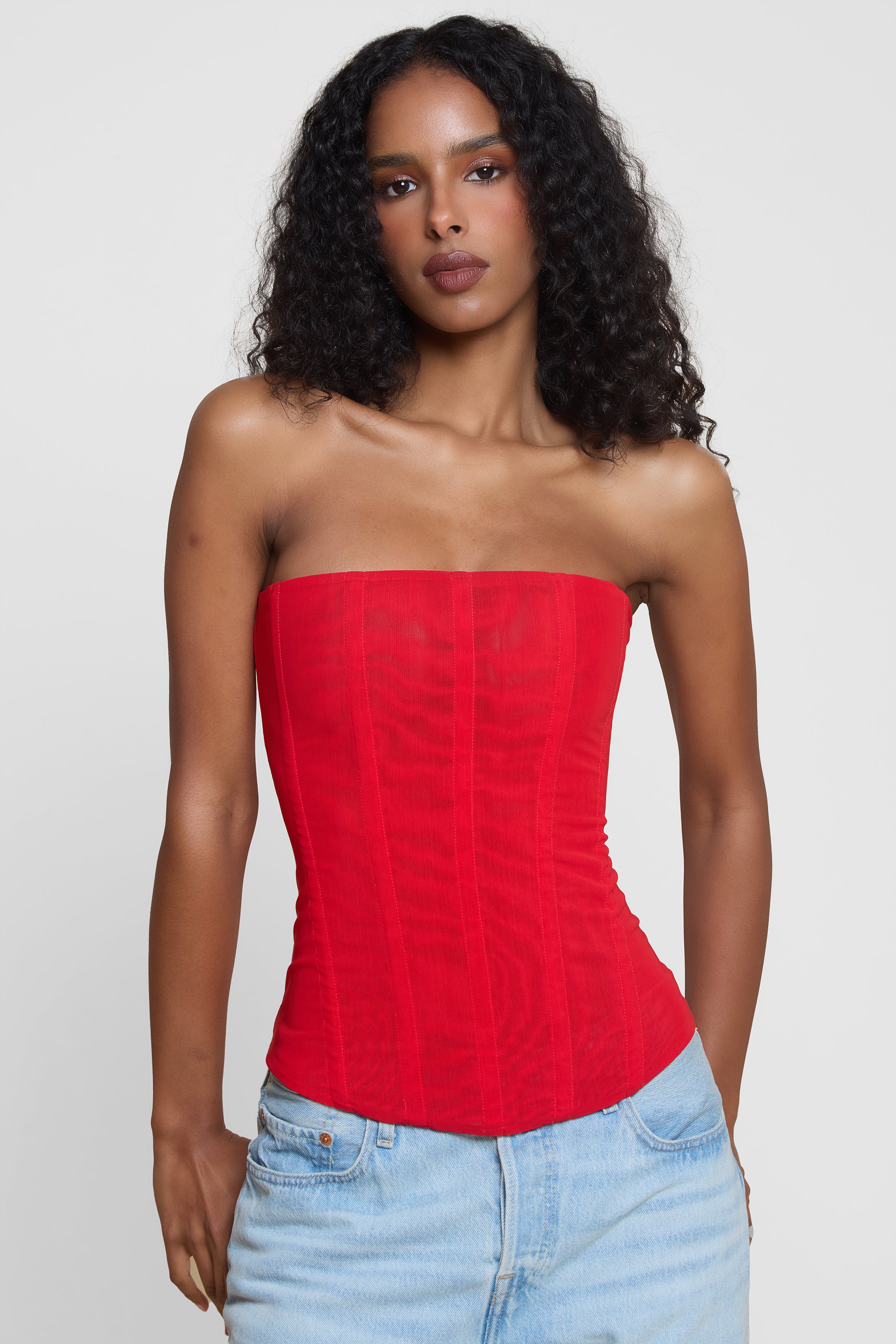 Model wearing Muse Mesh Corset Top in Red, front view.