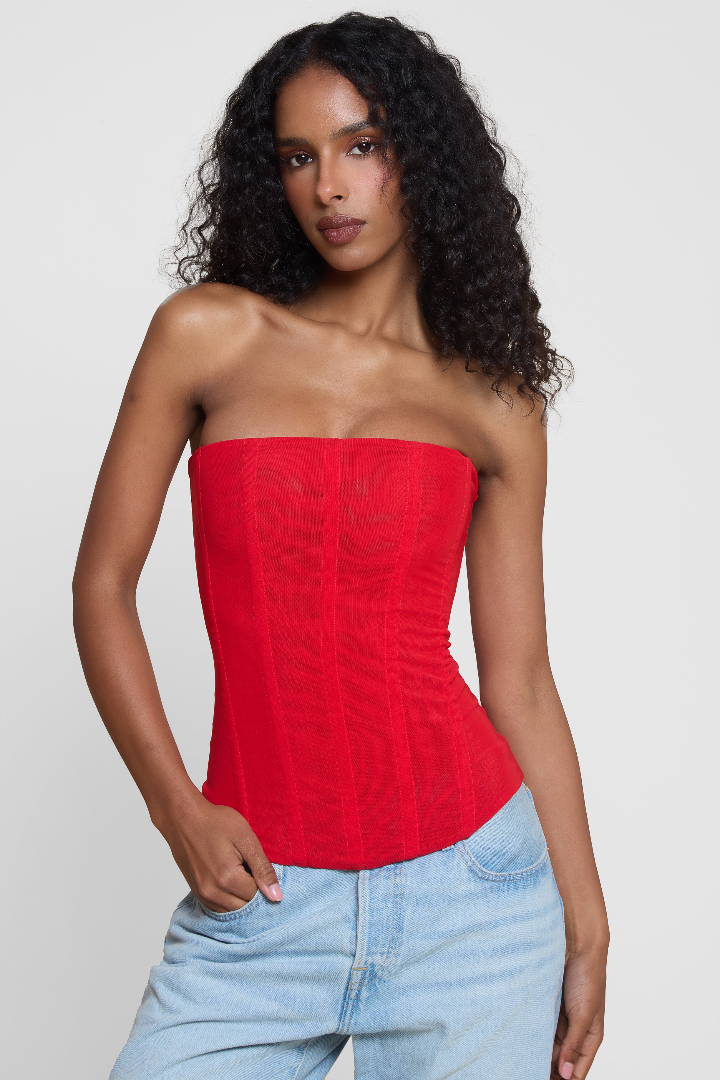 Model wearing Muse Mesh Corset Top in Red, front view.