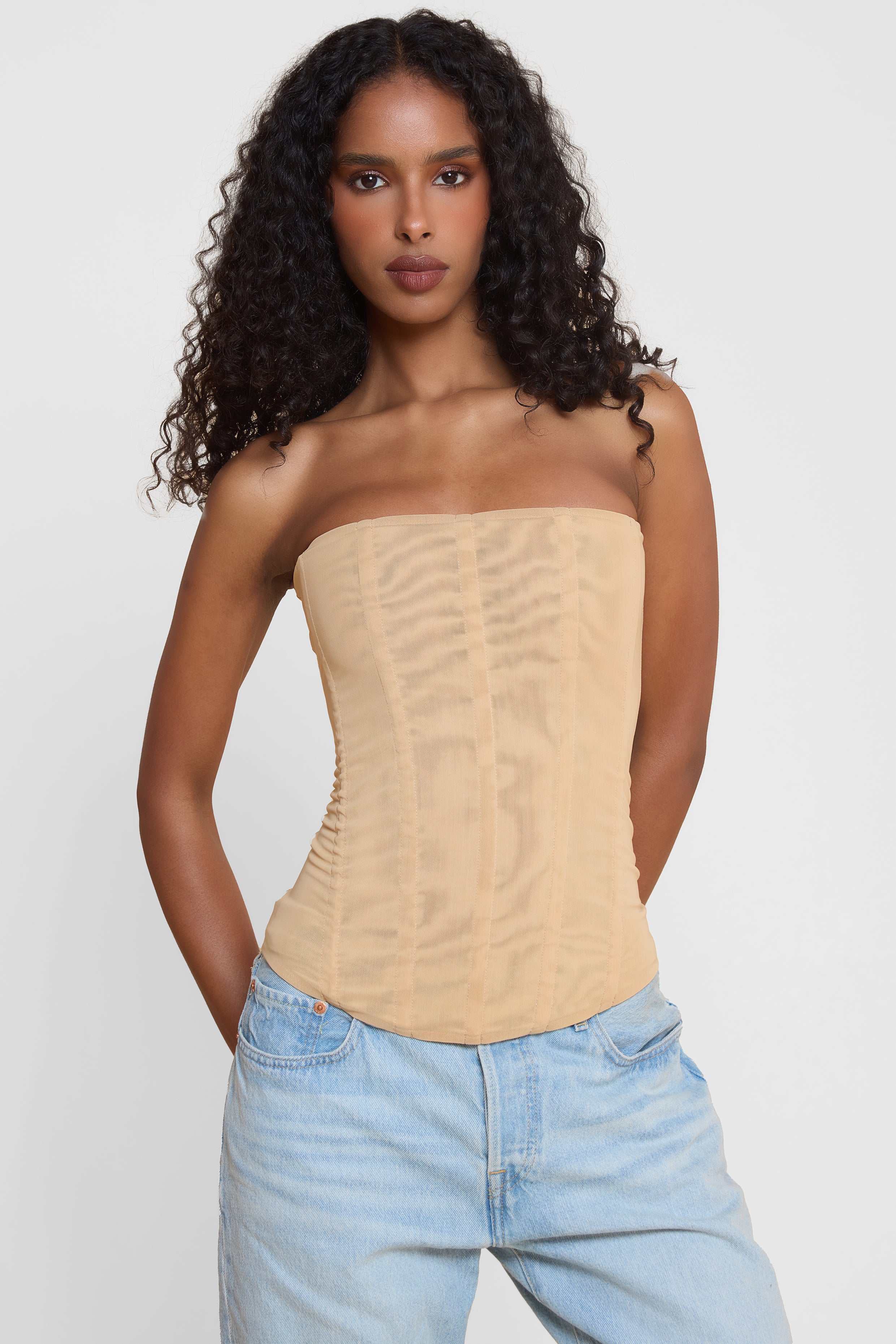 Model wearing Muse Mesh Corset Top in Tan, front view.