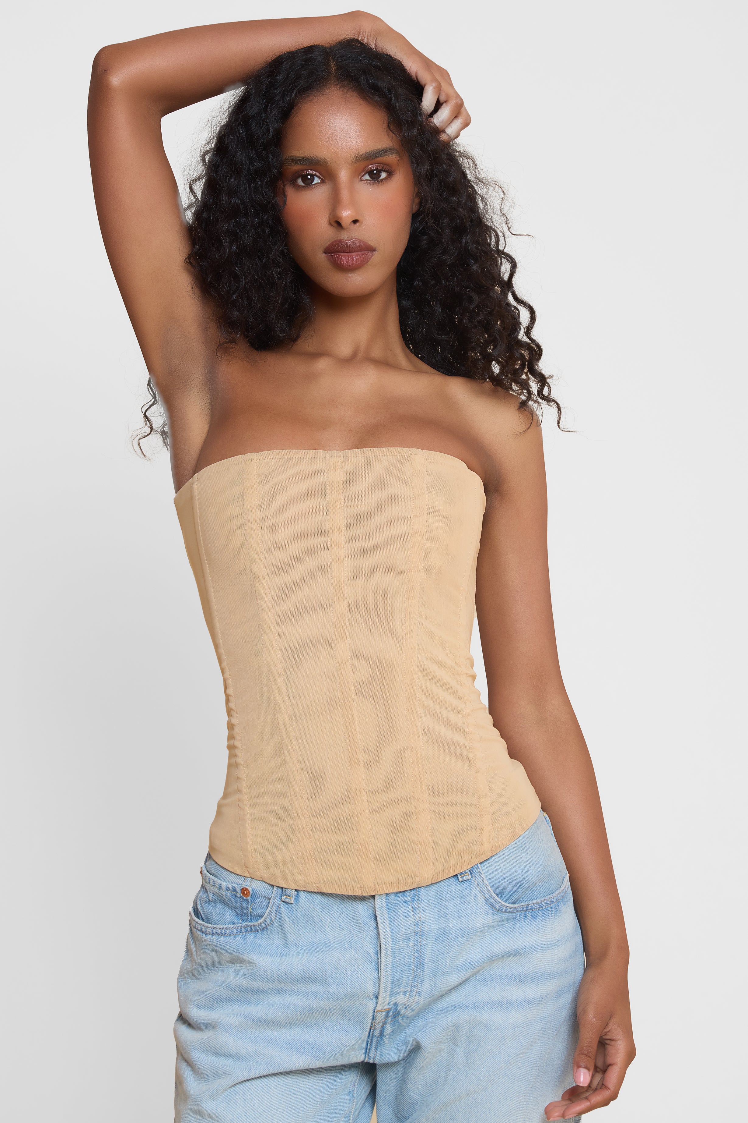 Model wearing Muse Mesh Corset Top in Tan, front view.