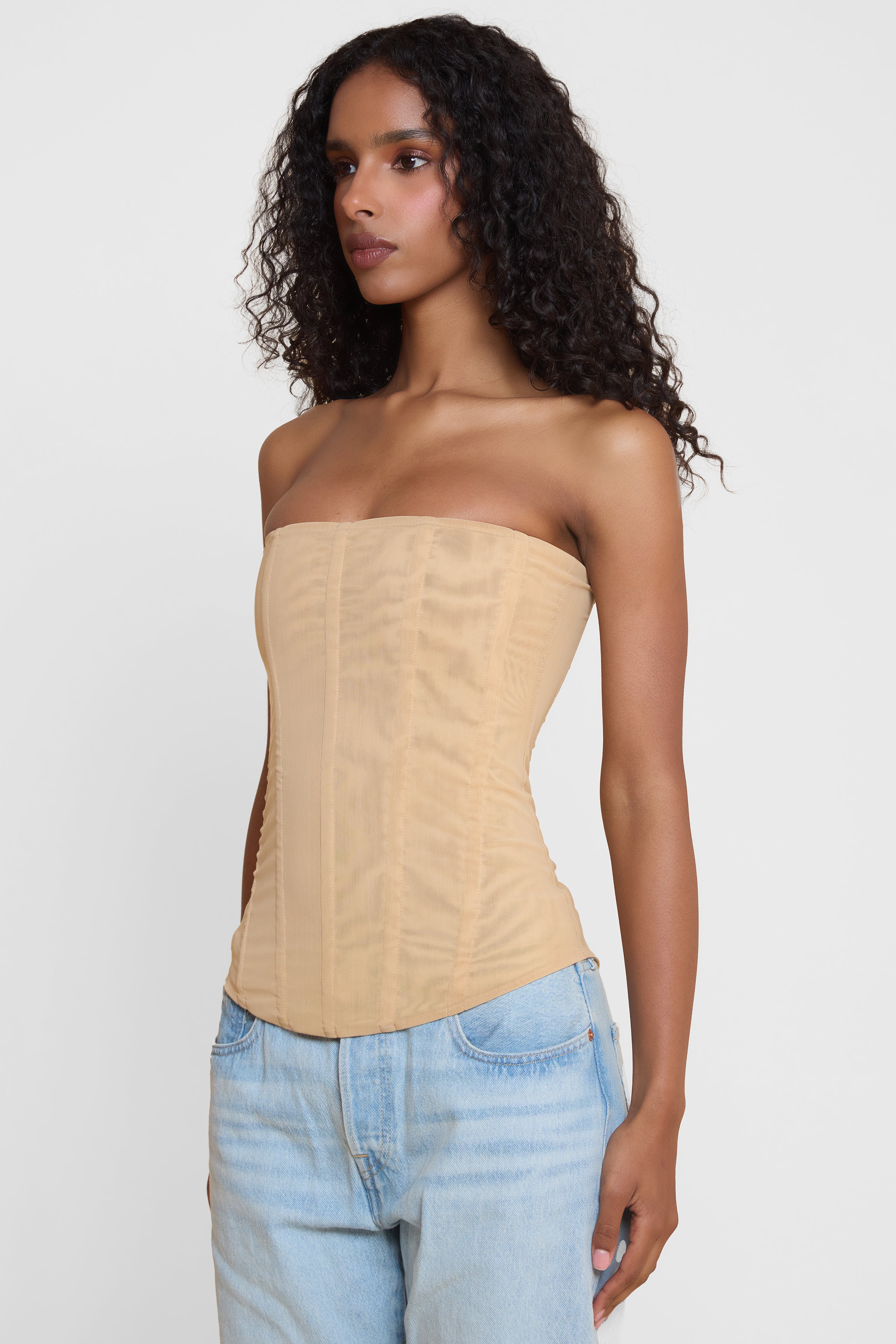 Model wearing Muse Mesh Corset Top in Tan, side view.