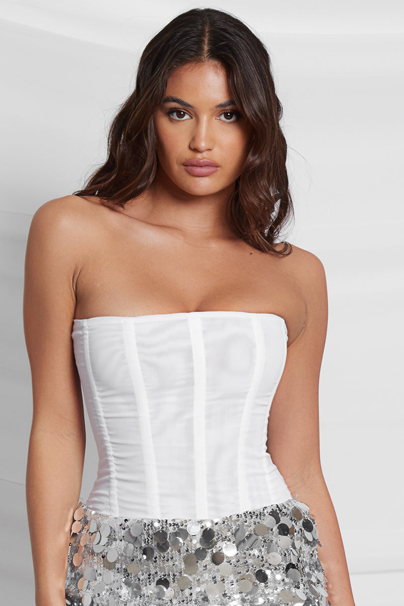 Model wearing Muse Mesh Corset Top in White, front view.