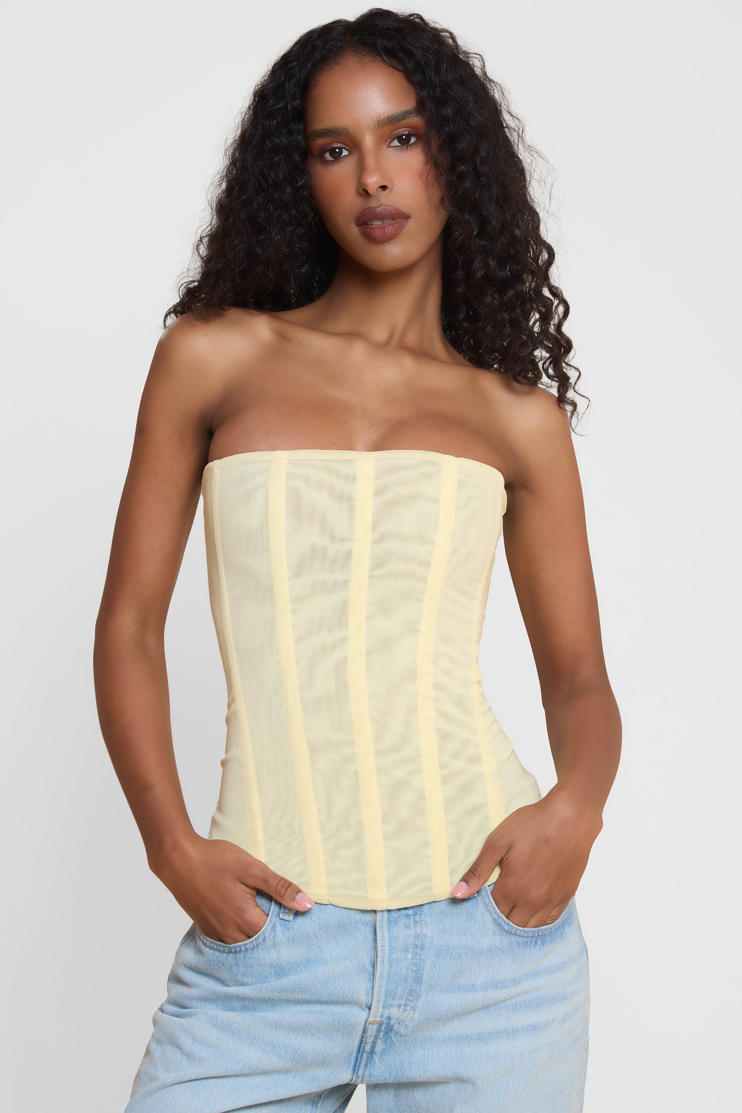 Model wearing Muse Mesh Corset Top in Yellow, front view.