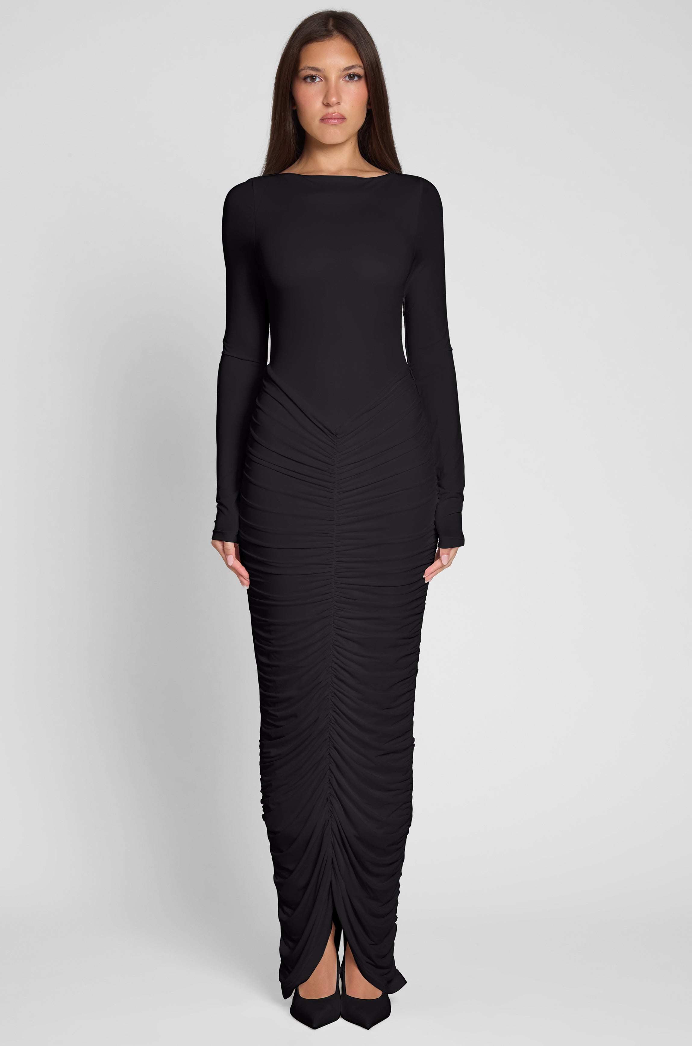 Model is wearing Rhea Ruche Maxi Dress in Black, front view.
