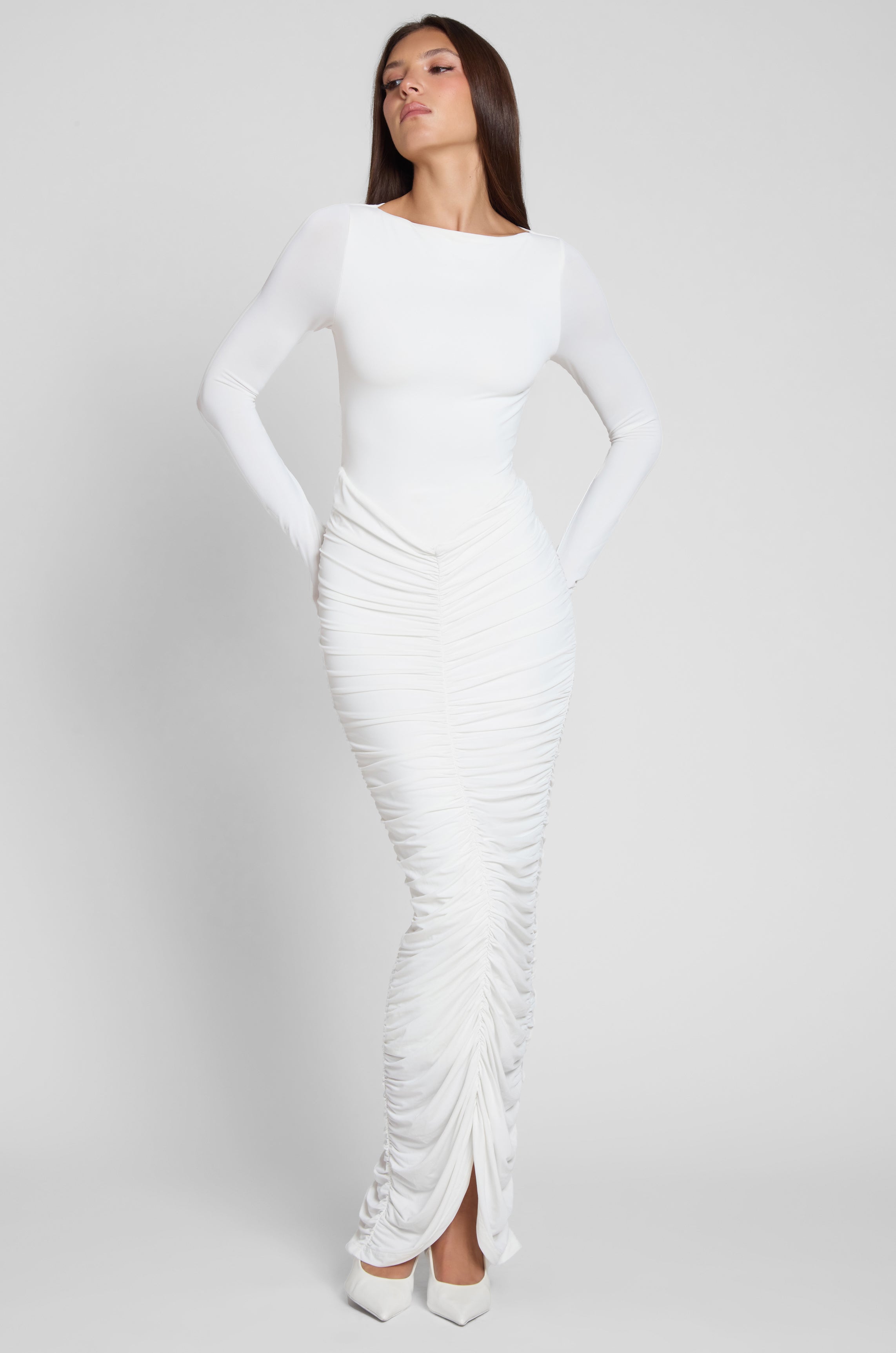 Model is wearing Rhea Ruche Maxi Dress in White, front view.