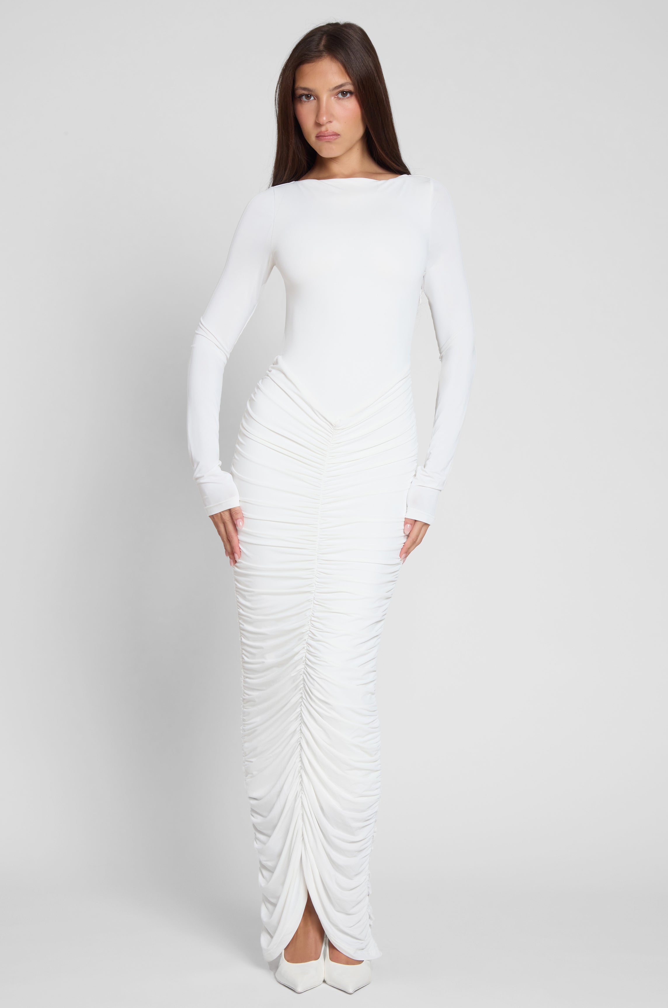 Model is wearing Rhea Ruche Maxi Dress in White, front view.