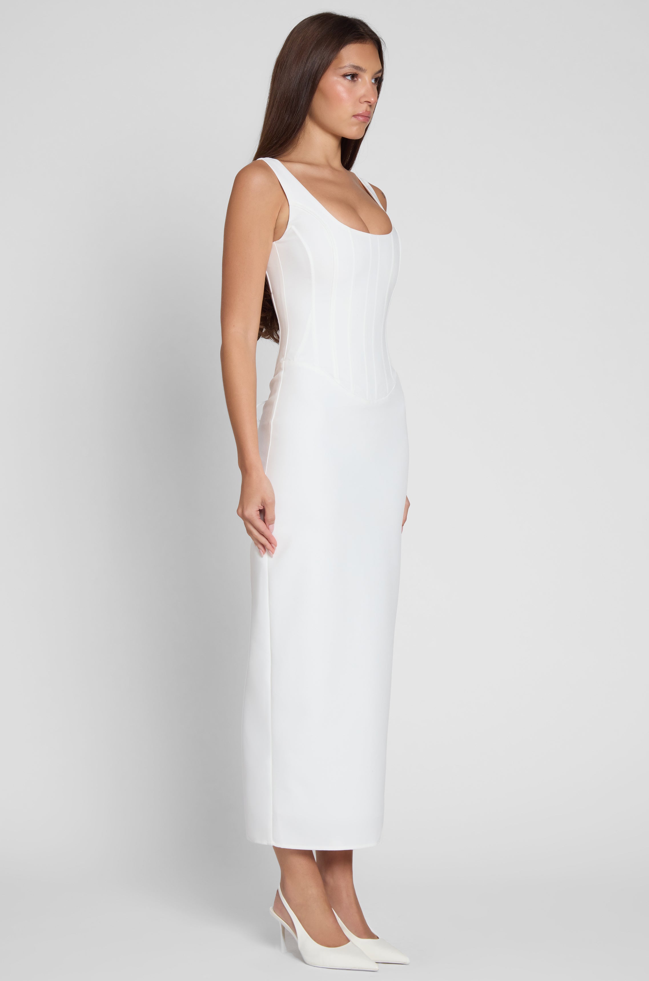 Model wearing Sancia Corset Midi Dress in White, side view.