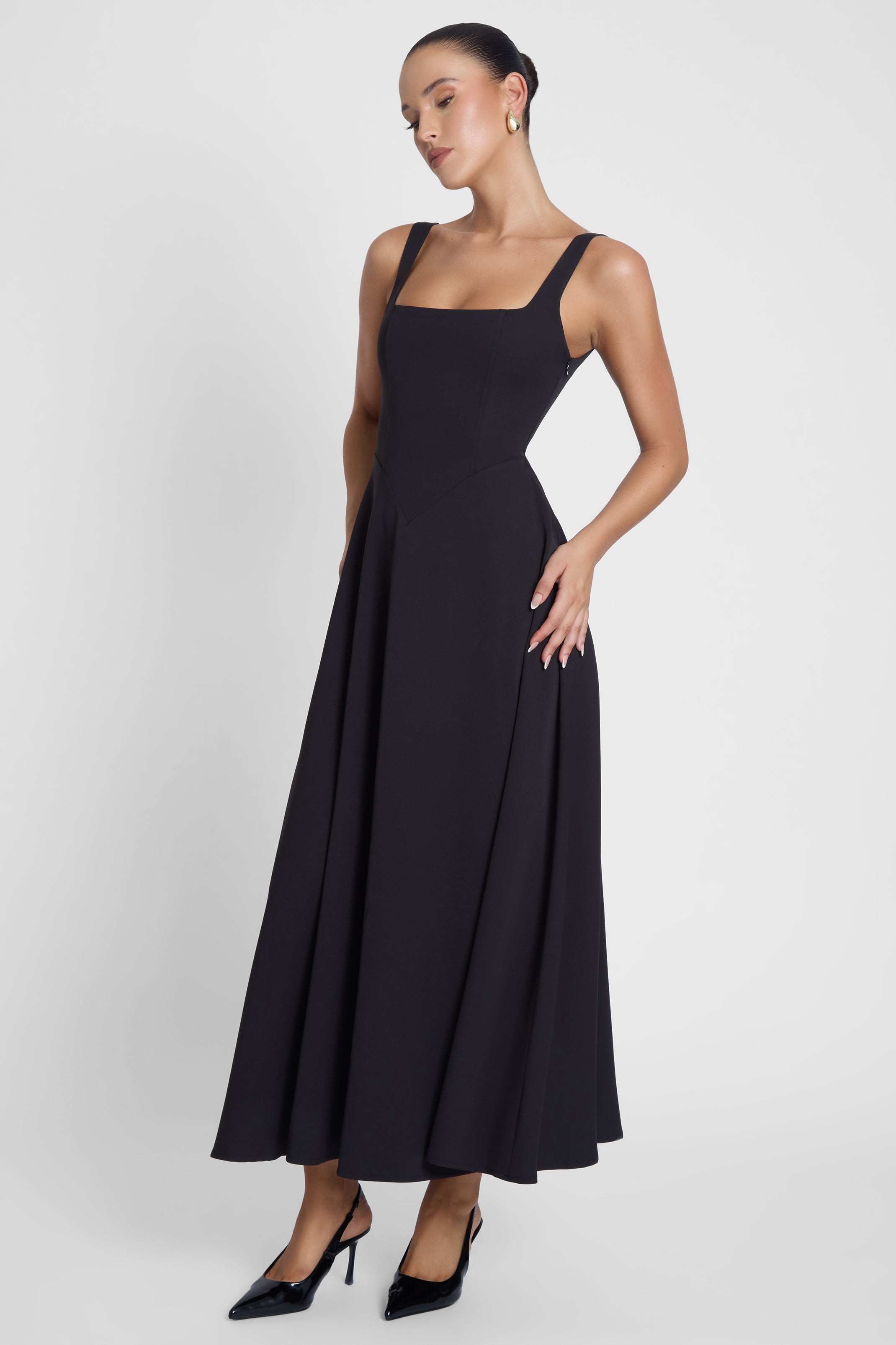 Model is wearing Serenity Square Neck Corset Midi Dress Black, side view.