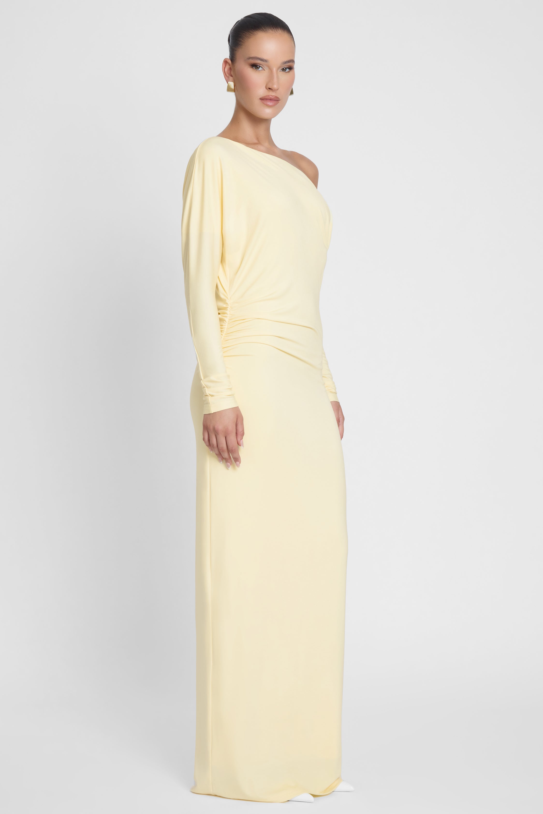 Model is wearing Sola Slouchy Jersey Maxi Dress Yellow, side view.