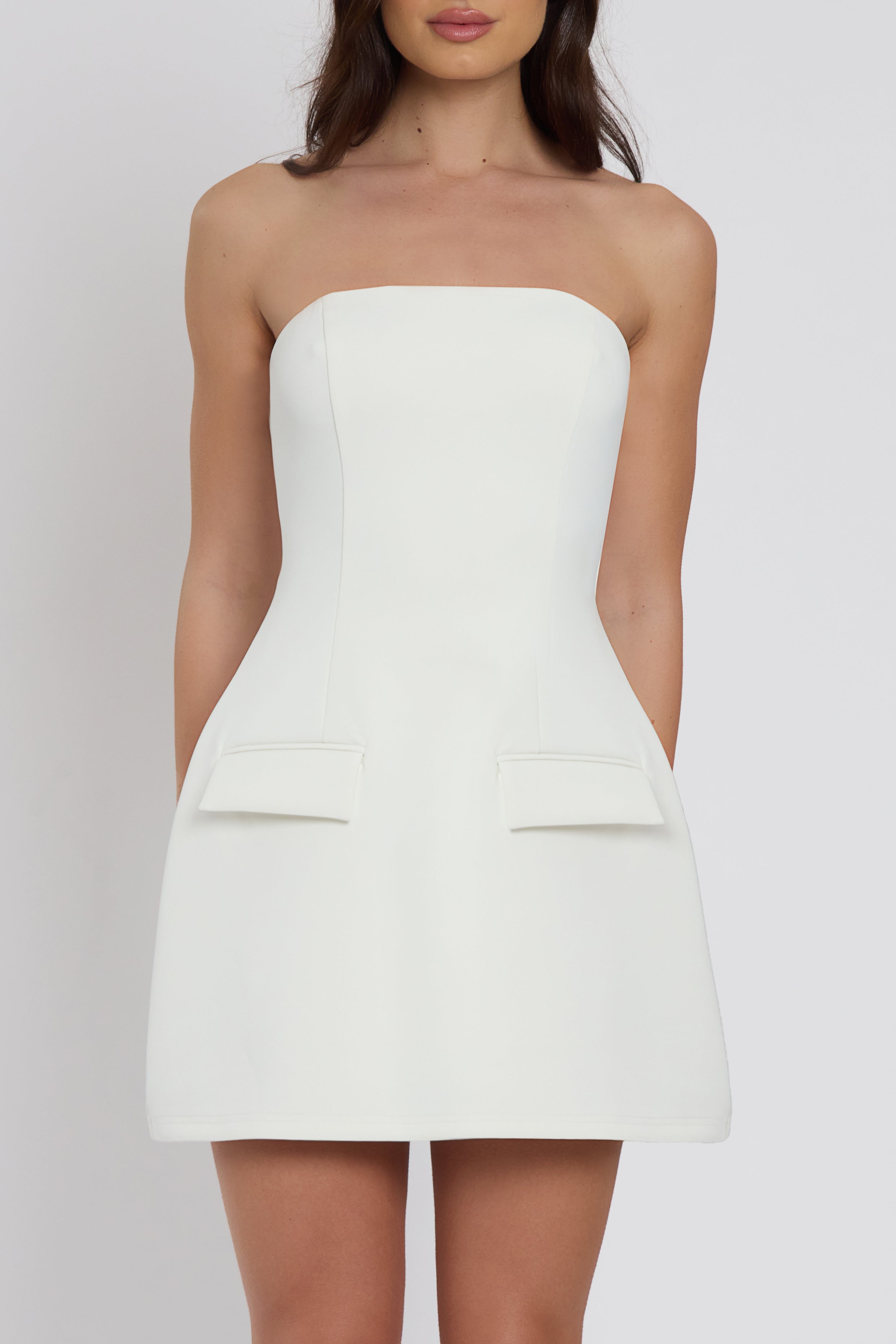 Model wearing Solene Strapless Pocket Mini Dress in White, front view.