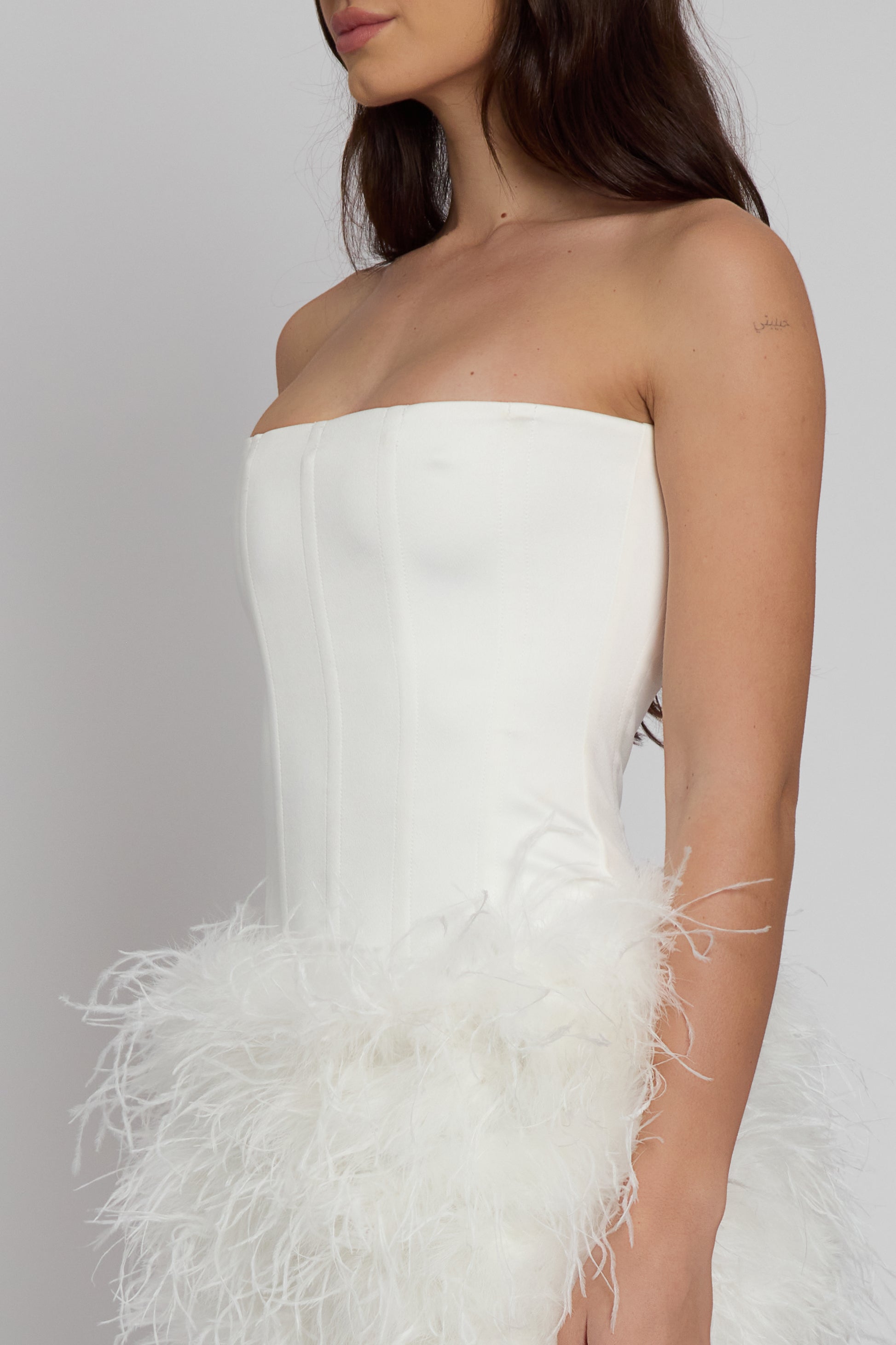 Model wearing Sphynx Satin Corset Top in White, side view.