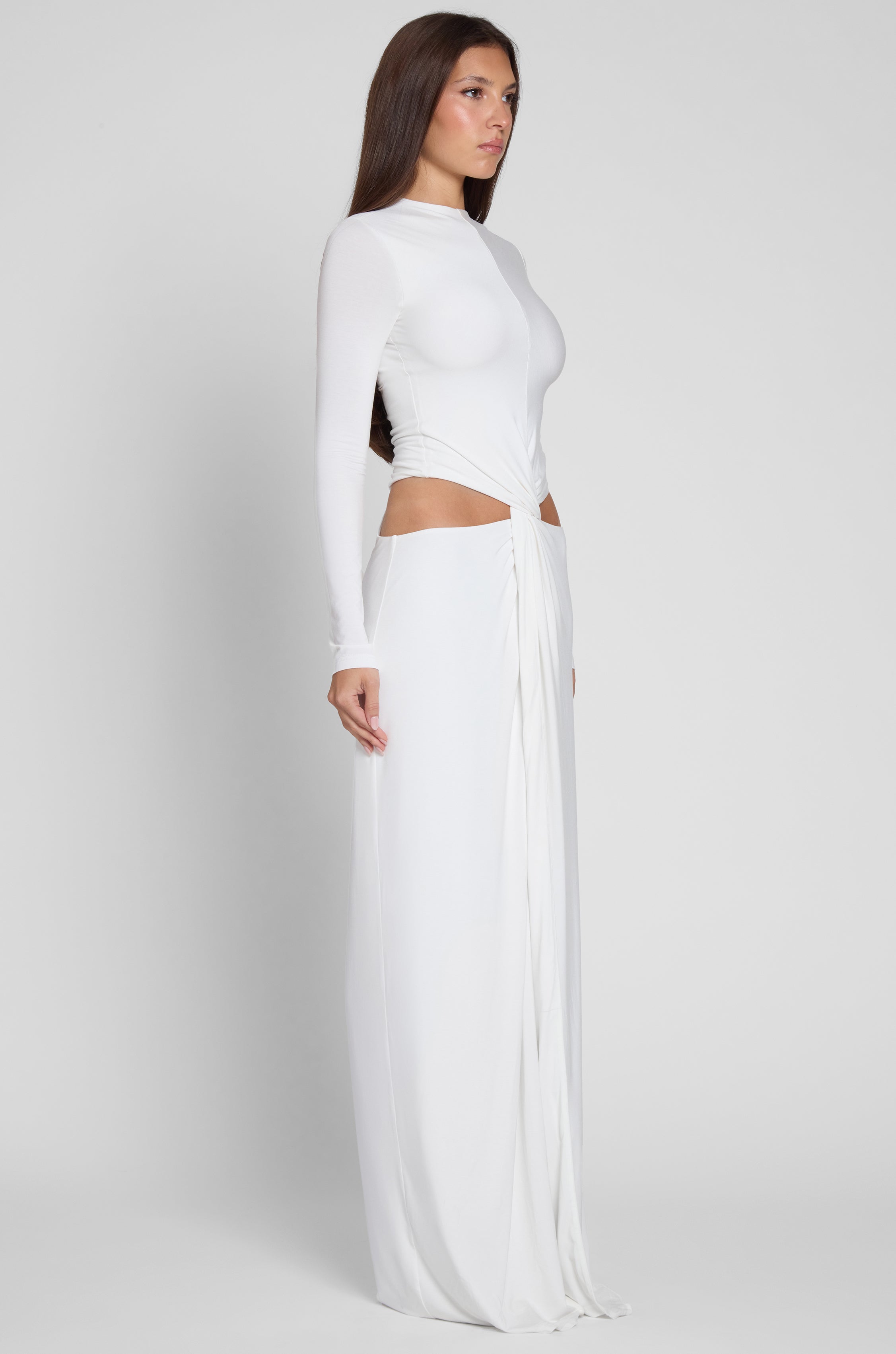 Model wearing Vacanza Drape Gown in White, side view.