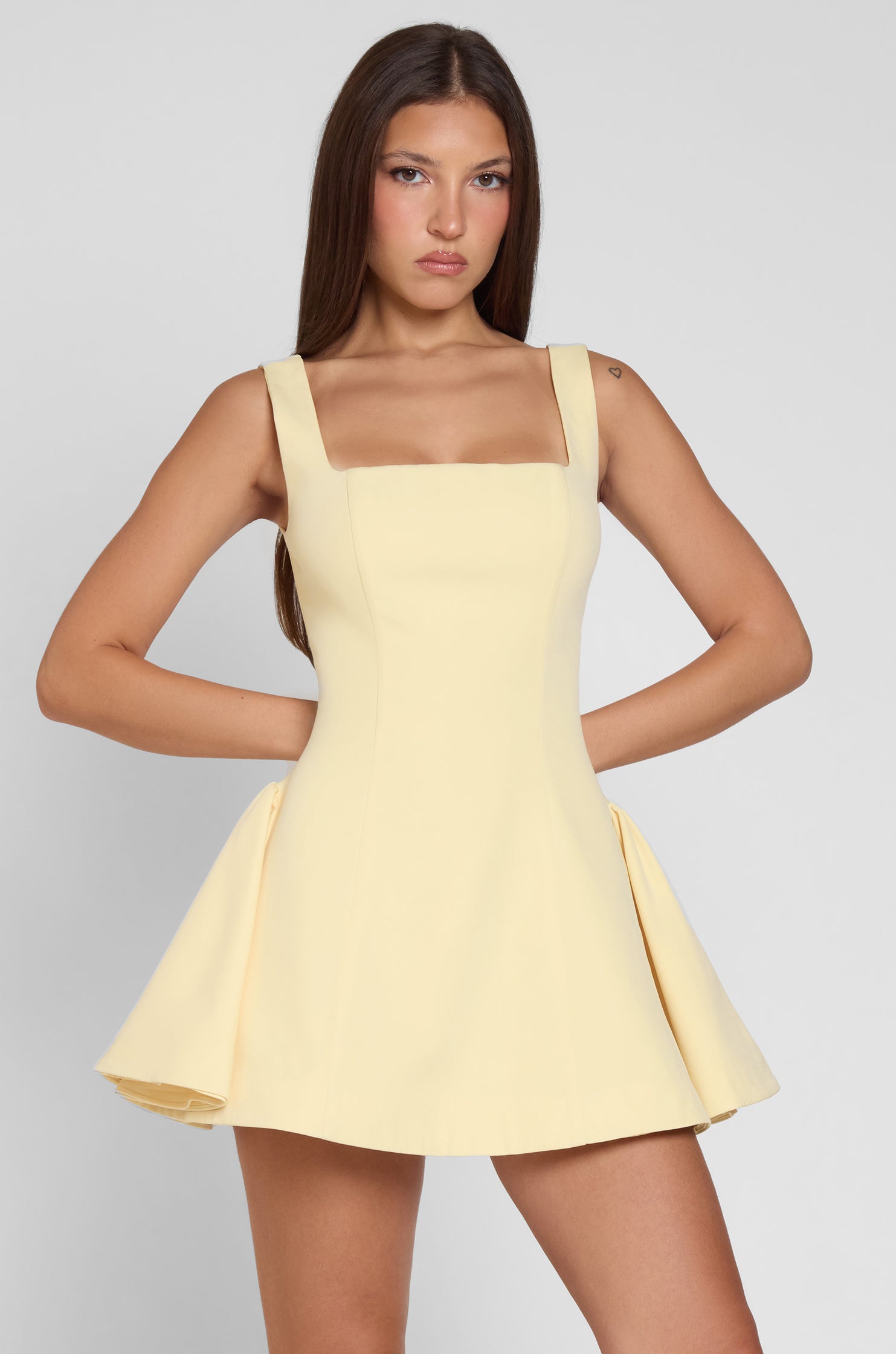 Model is wearing Ysabelle Babydoll Corset Mini Dress in Yellow, front view.